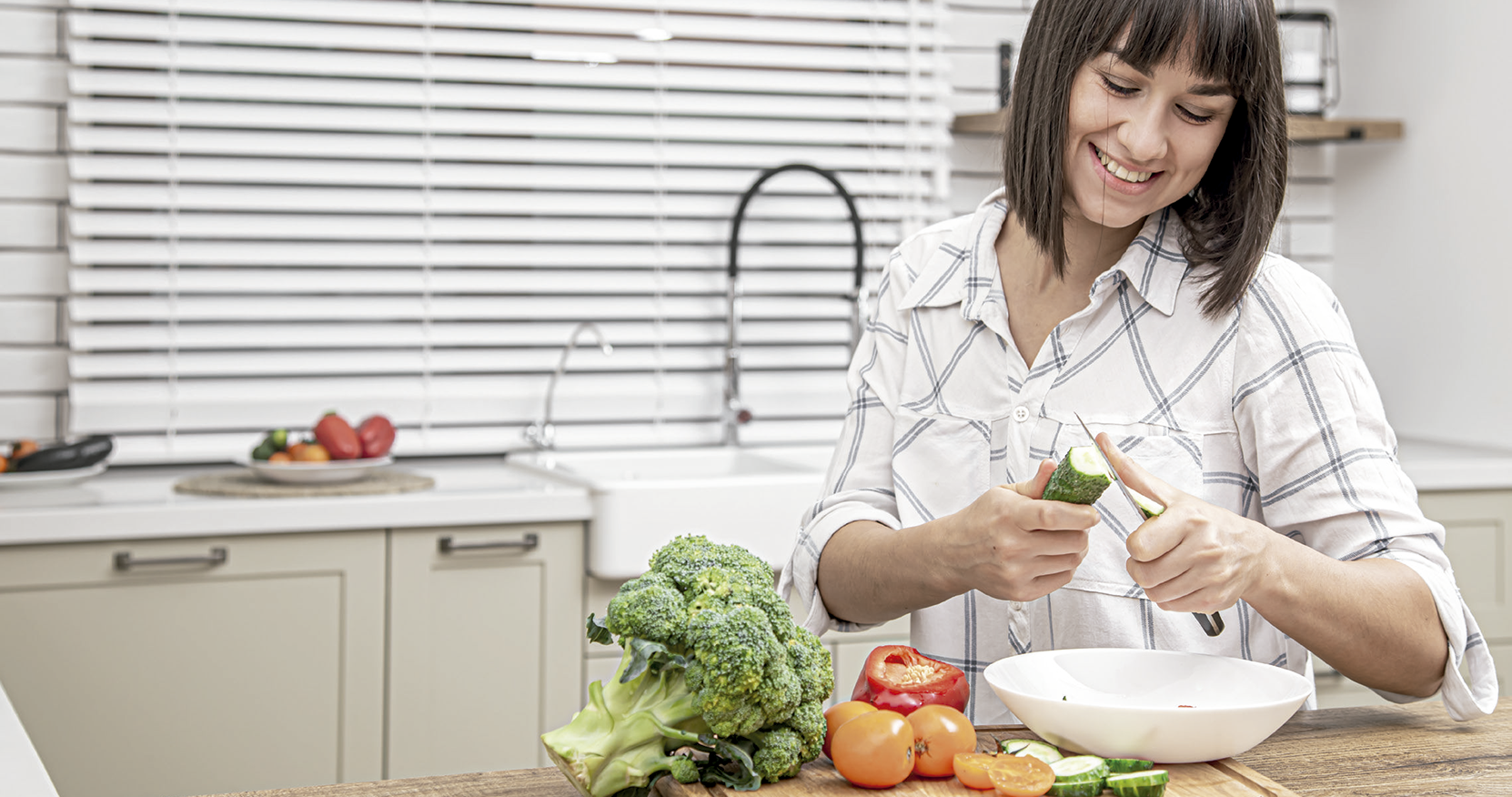 Una mujer prepara una comida en una cocina en la que se encuentra una Depuradora de Ósmosis Inversa Infinity ECO600